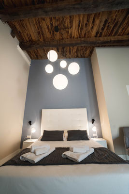 Schlafbereich mit Doppelbett und Beleuchtung in der Palinuro Suite in Pizzo, Kalabrien