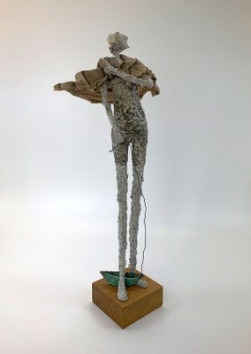 Skulptur eines Badegastes mit Boot und Handtuch aus veredeltem Pappmaché in Naturtönen von Claudia König.