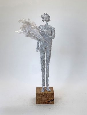 Monochrome Skulptur einer stehenden Figur im Wind | Ausdrucksstarke Faltenwürfe aus gehärtetem Papier-Komposit mit mineralischer Haptik.