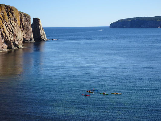 Urlaub in Quebec: Kanuten paddeln in ihren Kayaks vor dem Kalksteinfelsen Rocher Percé und der Bonaventure Insel.