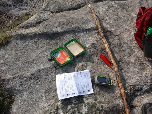 Der Cape Breton Highlands National Park hat seine eigene offizielle Geocaching-Challenge. Hier sieht man den Aufgabenzettel und die kleine rote Lochzange, dank der die Parkmitarbeiter wissen, ob man die Caches wirklich gefunden hat.