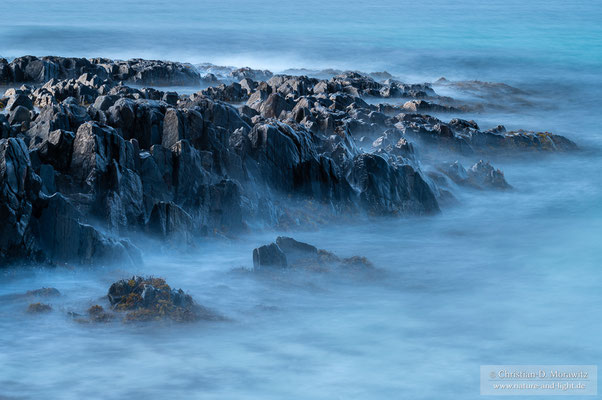 An dem schroffen Gestein brechen sich die Wellen der Barentssee