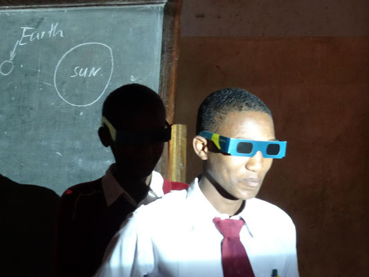Mondfinsternis: Der hintere Schüler (Mond) wird von der Sonne (Beamerlicht von rechts) nicht angeleuchtet, da er sich im Erdschatten (vorderer Schüler) befindet.