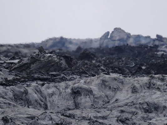 Durch die Hitze der Lava in vorderen Bildteil ist der Hintergrund des Bildes durch Hitzeflirren extrem verzerrt.