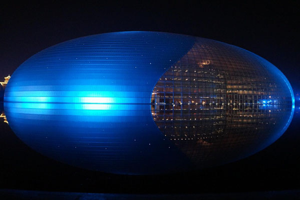 Das von Wasser umgebene Pekinger Nationaltheater bei Nacht.