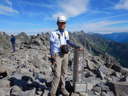前穂高岳山頂で、槍ヶ岳をバックに記念撮影。