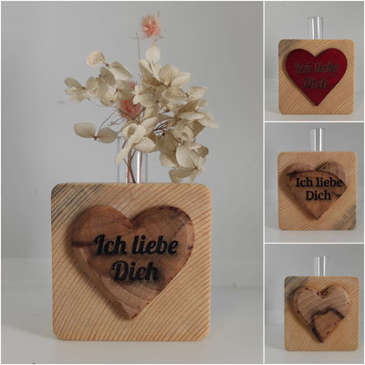 Kleine handgefertigte Holzvase mit Herzform und zarten Trockenblumen als liebevolle Dekoration