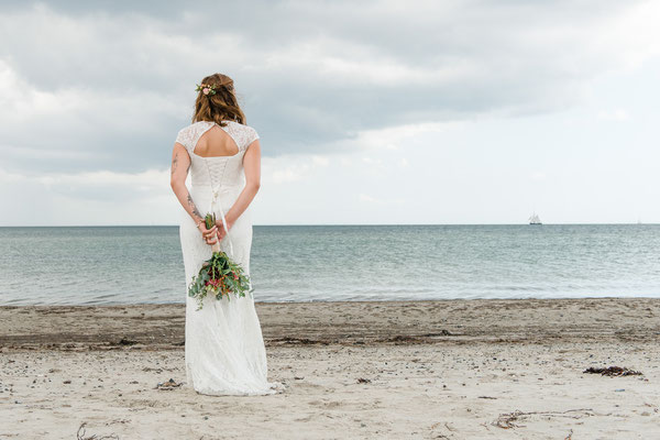 Braut am Strand vor dem Leuchtturm Falshöft
