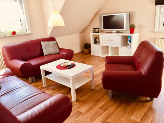 Wohnzimmer mit gemütlicher Couch, TV-Gerät