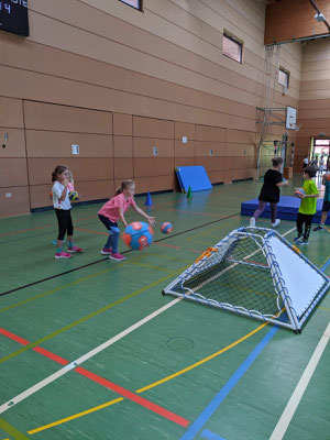 Die Kinder trainieren Bälle zu werfen und zu fangen