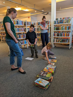 Die Kinder sortieren verschiedene Bücher auf Stapel