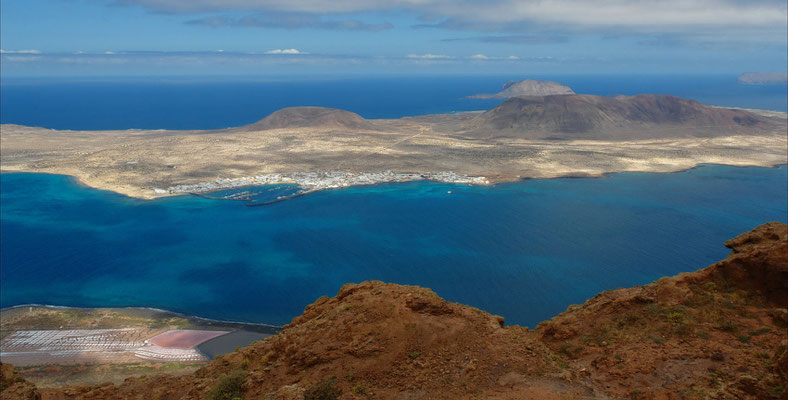 Blick vom Mirador del Río nach NW auf die Inseln La Graciosa, Montaña Clara und Alegranza (rechts), unten links die Salinas del Río