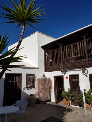 Galeriehof. Balkon mit einem Holzgitterwerk im Stil der traditionellen Inselarchitektur