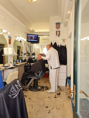 Friseur in einem kleinen Geschäft des Stradun