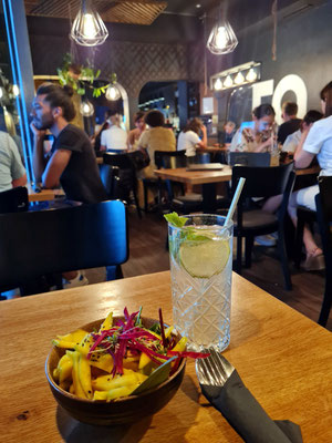 Fruchtiger Mangosalat mit rerösteten Erdnüssen, Lotusstiele, Sesam und einem Limetten-Ingwer Dressing. Als Getränk hausgemachte Limonade mit frisch gepresstem Limettensaft, Soda und Rohrzucker