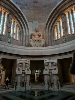 Blick in die Krypta mit den Schicksalsmasken und den trauernden Kriegern, darüber die Ruhmeshalle mit den vier 10 m hohen Sitzfiguren, hier sichtbar die weibliche Figur der Volkskraft