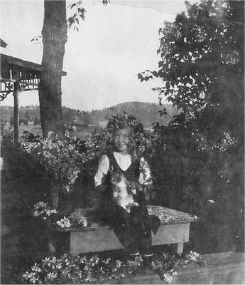 Vivian Johnson with her cat, covered in apple blossoms.