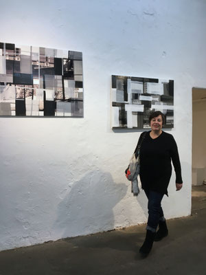 Monika Humm vor Arbeiten aus der Serie "global - men at work" im Kunstverein Ebersberg