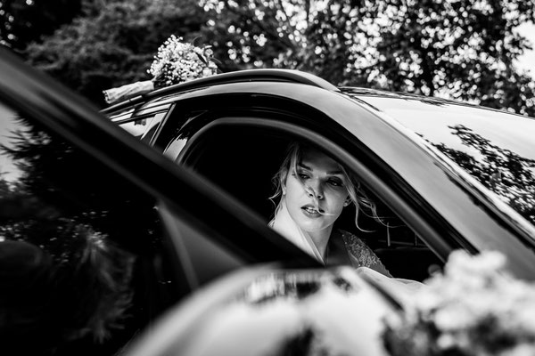 Braut steigt aus dem Auto.