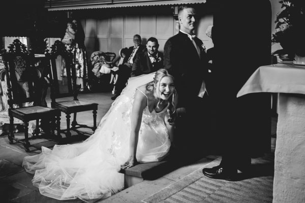 Braut stolpert vor dem Altar in der Kirche und lacht.
