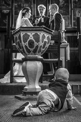 Ein Baby krabbelt in der Kirche Richtung Altar.