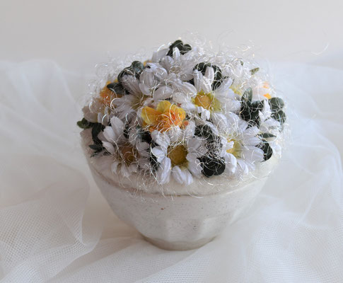 Gesteck mit Margeriten und Rosen im weißen Keramiktopf.