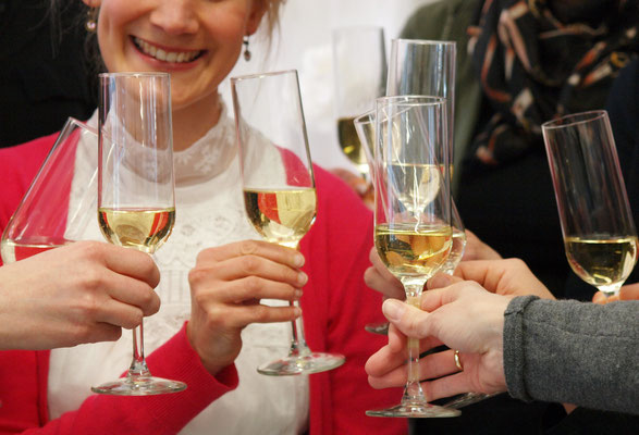 Kolleg:innen stoßen mit Sekt in der ELA EIS Location in Düsseldorf an