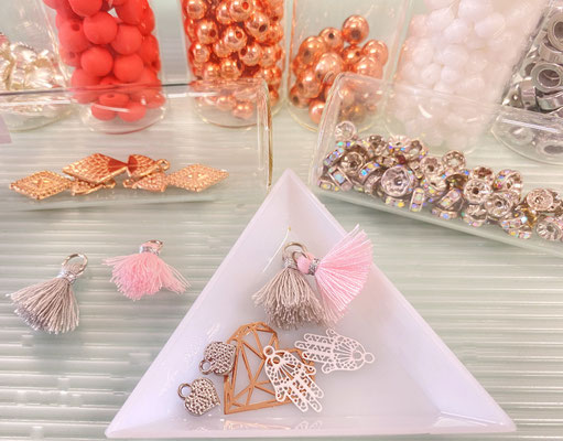 Schmuck DIY Workshop Schalen mit bunten Perlen und Anhängerchen  auf einem Tich