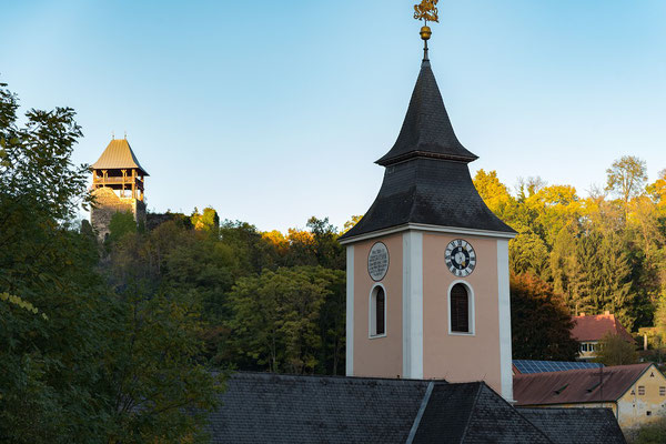 Kirche mit Burgruine im Hintergrund