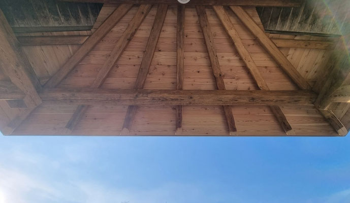 Strahlenförmige Untersicht einer Überdachung aus Altholz