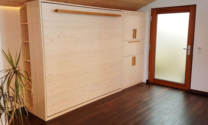 Klappbettschrank weiß lasiert mit Möbelgriffen aus Eiche. Dazu ein Barschrank mit Stauraum