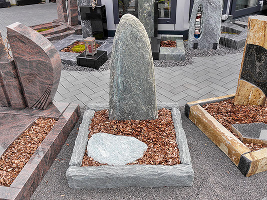 Urnengrab aus unbehandeltem Naturstein mit Stein in Felsform und kleiner Liegeplatte