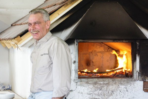 Bernd Storch am selbst gebauten Holzbackofen beim Pizzabacken