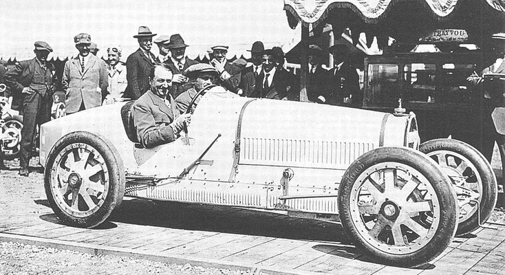 Ettore Bugatti achter het stuur van zijn nieuwe racewagen Type 35 bij de Grand Prix van 1924 in Lyon.