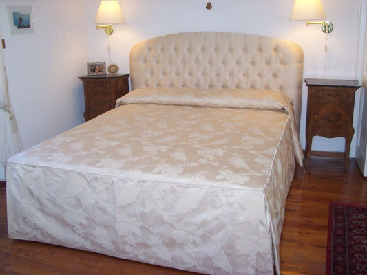 Letto con testata curva in capitonnè