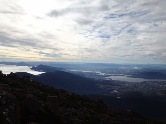 Von links schieben sich Wolken zwischen den Bergen Richtung Hobart vor