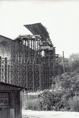 Die vorgefertigten Stahlelemente der Fahrbahn für die Behelfsbrücke werden per Eisenbahnkran eingehoben. 1984, Foto: Archiv Sven Kasperzek.