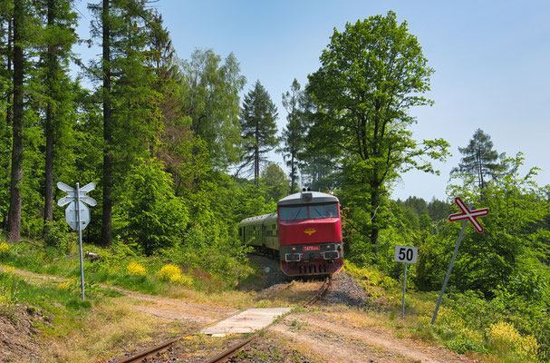 T478 1215 mit dem Lužickohorský rychlík Prag - Mikulášovice dolní nádraží bei Brtníky, Mai 2023.