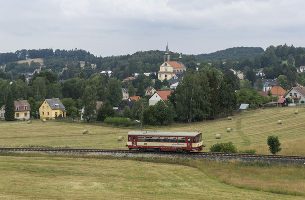 810 165-1 ( jetzt mit der Aufschrift "Regio Mouse") auf seinem Weg nach Rumburk in der Ortslage von Mikulášovice. Im Hintergrund das Kostel sv. Mikuláše, 29.07.18