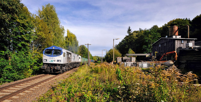 Blue Tiger 250 007 der ITL mit einem Schotterzug aus dem Steinbruch Oberottendorf. Nach Ausfahrt aus dem Bahnhof Neukirch / Lausitz (West) geht es vorbei am Sägewerk in Richtung Dresden, September 2012.
