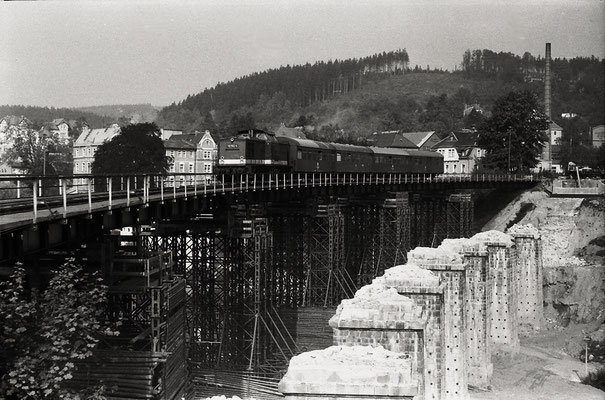 P 18873 nach Bad Schandau hat Sebnitz gerade verlassen . Vom ehemaligen schönen Sebnitzer Viadukt sind nur noch die Pfeiler zu sehen. Der Zugverkehr lief während dem Neubau über eine Behelfsbrücke. Sommer 1986, Foto & Infos: Lutz Morgenstern