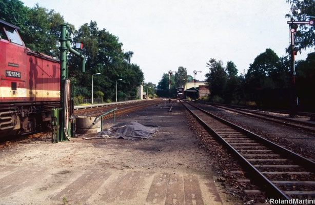 Blick vom Inselbahnsteig in Richtung Ausfahrt Neustadt mit 112 561-6, dem Wasserkran, den Ausfahrsignalen C, D und E, dem Stellwerk 1 (Stw1) und dem Anschluß zum Kohlehandel rechts neben dem Stellwerk. Mai 1990, Foto: Archiv Roland Martini