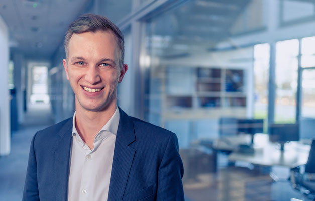 Ein Mitarbeiter posiert für ein Portrait. Corporate-Fotografie, Businessportrait Portrait 