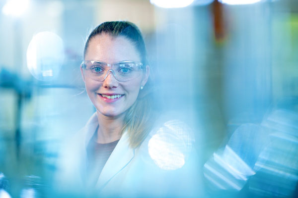 Portrait einer Mitarbeiterin an ihrem Arbeitsplatz im Labor. Corporate-Fotografie, Businessportrait 