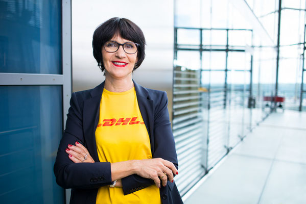 Eine DHL Mitarbeiterin posiert für ein Portrait. Corporate-Fotografie, Businessportrait Portrait 