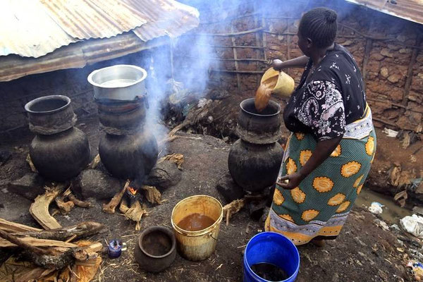 Una donna impegnata nella preparazione del "chang'aa" a Kibera (Nairobi)
