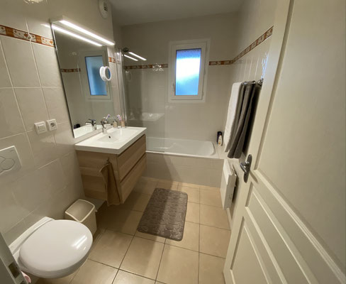 Badkamer met bad en badkamermeubel beneden