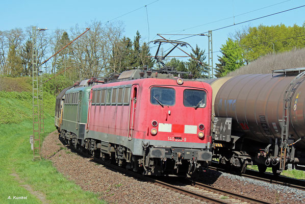 Mit dem "Henkel-Zug" überführt die Bayernbahn hinter der Zuglok 140 850 am 19. April 2018 die 140 438. In Hanau-Großauheim begegnet der Zug einem Kesselwagenzug.