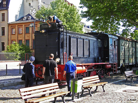 An der Zugspitze hängt V36 406, die kurz vor der Abfahrt unter Beobachtung des Zugpersonals an der Station "Eiserner Steg" noch blank gewienert wird (21. Mai 2018).