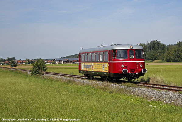 Am 13. August 2023 fährt VT 26 der Chiemgauer Lokalbahn als P 142 von Obing nach Bad Endorf, hier kurz hinter Halfing.